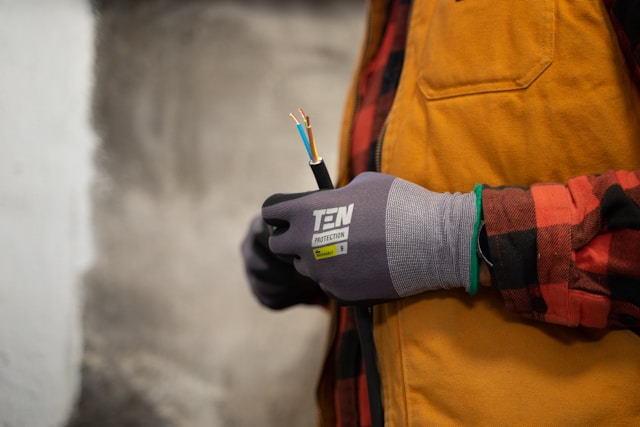 elektryk trzymający w swoich rękach kabel prądowy bez wtyczki